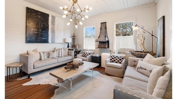 A spacious living room with a large sofa, a coffee table, and a fireplace.