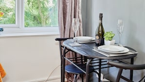 A dining table set with plates, cutlery, a wine bottle, and a glass. - Charming City 1-bed Apartment in Birmingham (Birmingham)