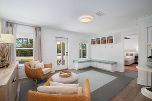 Un salon moderne avec un canapé, un pouf et un banc le long du mur.