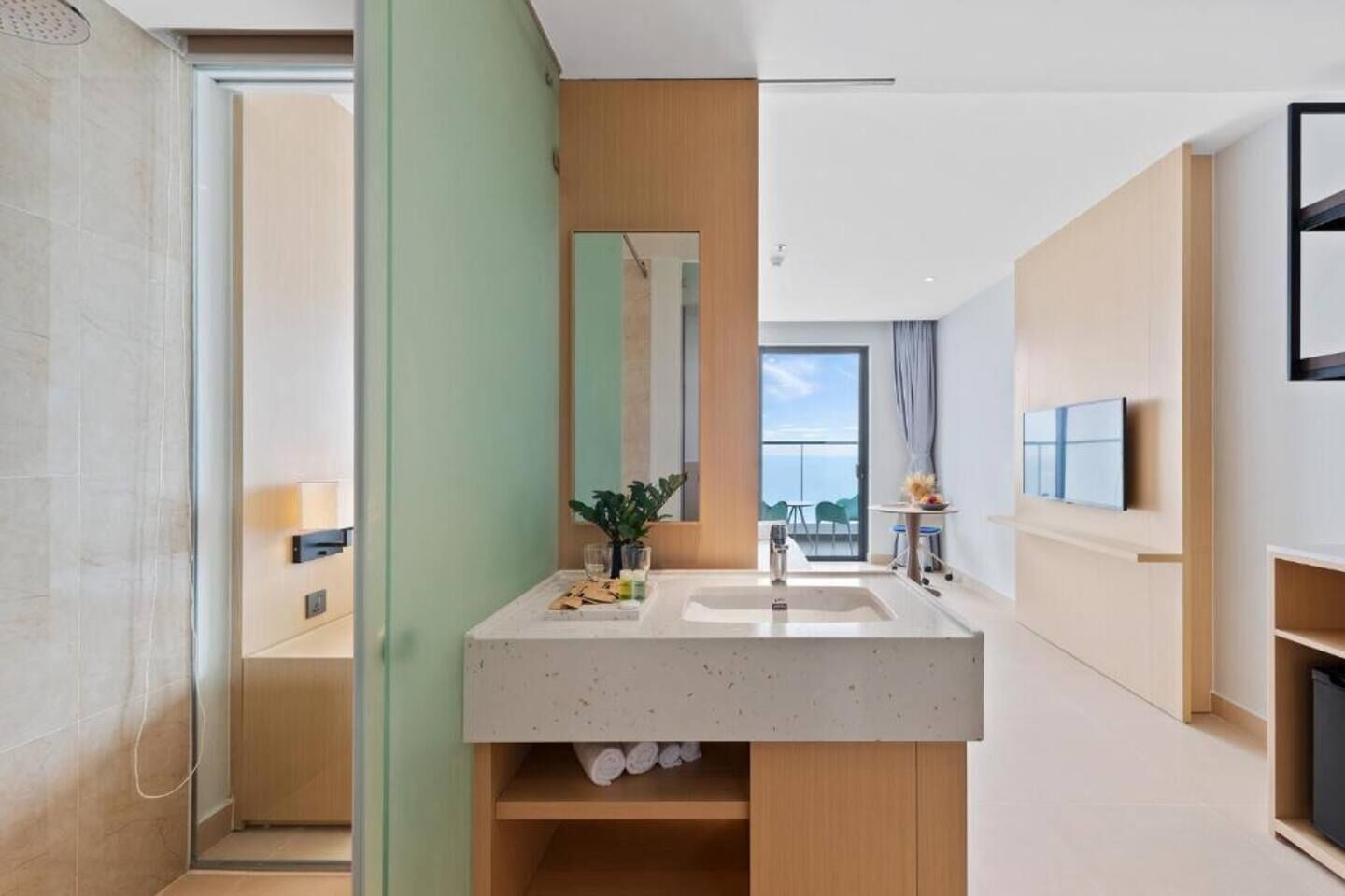 A modern bathroom with a large mirror, a sink, and a shower area.
