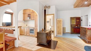 A spacious kitchen with wooden cabinets, a stove, and a large window. - Apartment 'Premesan 5' with Wi-Fi (Bormio)