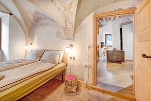 A bedroom with a wooden bed, a small stool, and a wooden wardrobe. - Apartment 'Premesan 5' with Wi-Fi (Bormio)