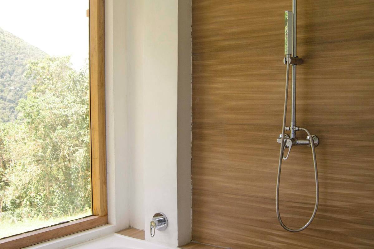 Um banheiro moderno com toucador de madeira, banheira de pé e chuveiro com chuveiro manual.