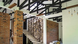 Un interior moderno con paredes de ladrillo visto, una escalera y un comedor con mesa y sillas.