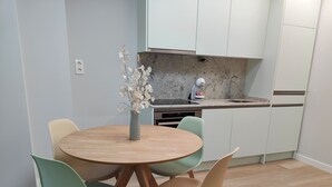 A modern kitchen with white cabinets, a granite countertop, and a built-in dishwasher. - Loft Moderno, Céntrico y Acogedor (Oviedo)