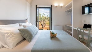 A modern hotel room with a bed, a desk, and a TV. - Villa Belkis 6, Emma Villas (Ostuni)