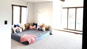 A cozy bedroom with a large bed, a window, and a wooden ceiling beam. - Life-Giving, Quiet retreat only 25 min west of Indpls. Peace, Pace, & Gratitude (Coatesville)