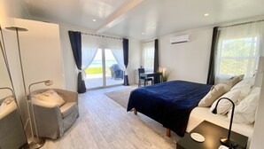 Ein modernes Hotelzimmer mit Bett, Schreibtisch und einem Balkon mit Grill.