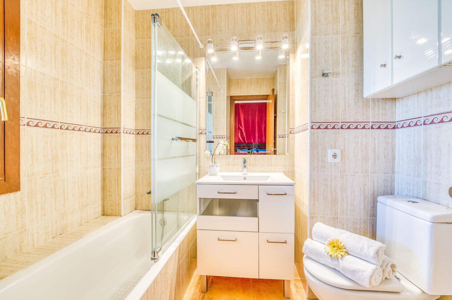 Une salle de bain moderne avec une douche à parois de verre, un meuble-lavabo avec un miroir et des toilettes.