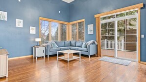 A living room with a blue wall, a gray sectional sofa, a white coffee table, and a wooden floor. - Wonderful home in prime Rosemount location.

 (Rosemount)