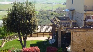 A rural house with a stone wall, a tiled roof, and a view of the countryside. - THE HOUSE OF CHIANNI "La Pieve 2" (CHIANNI)