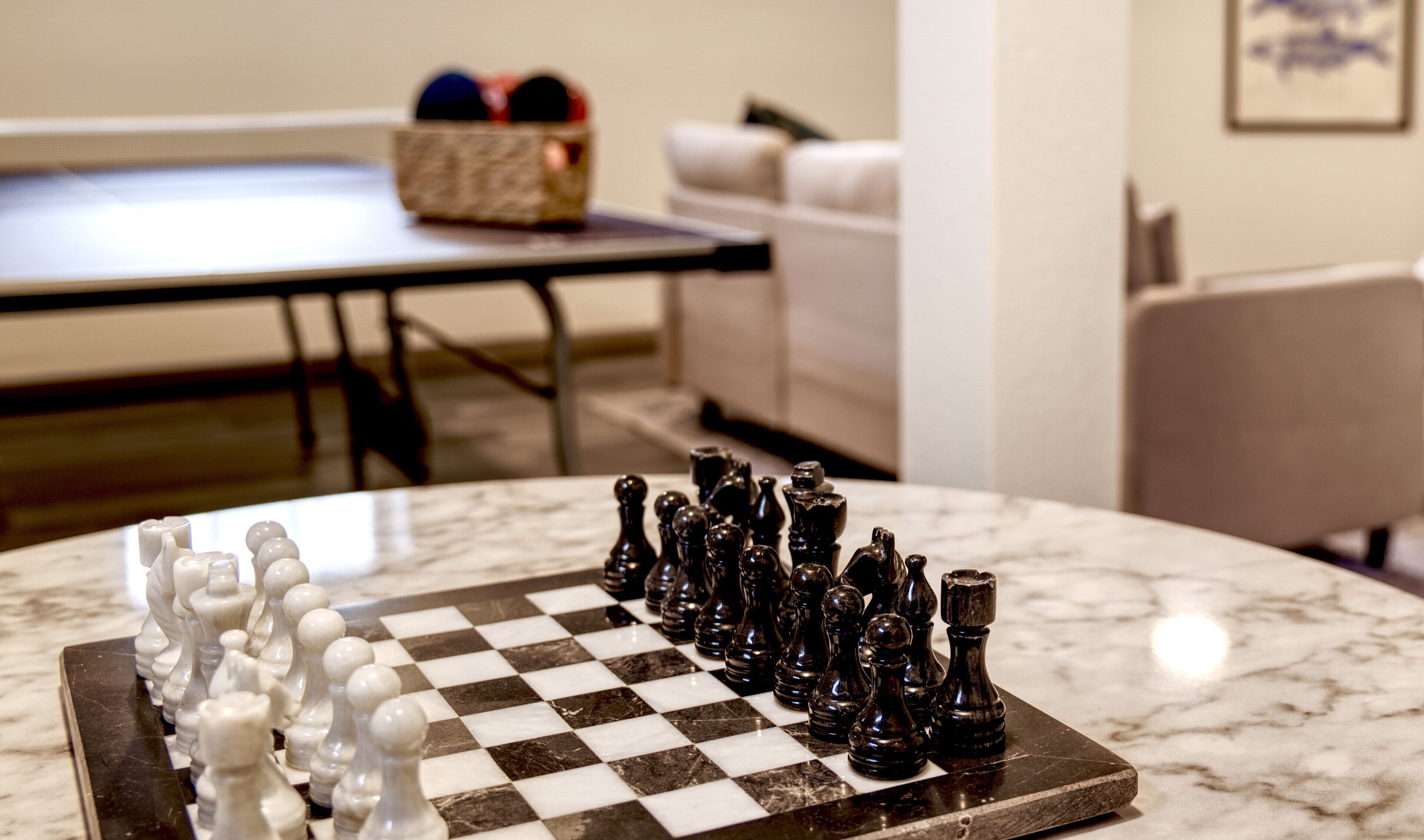 A chessboard on a marble table with a checkered pattern.