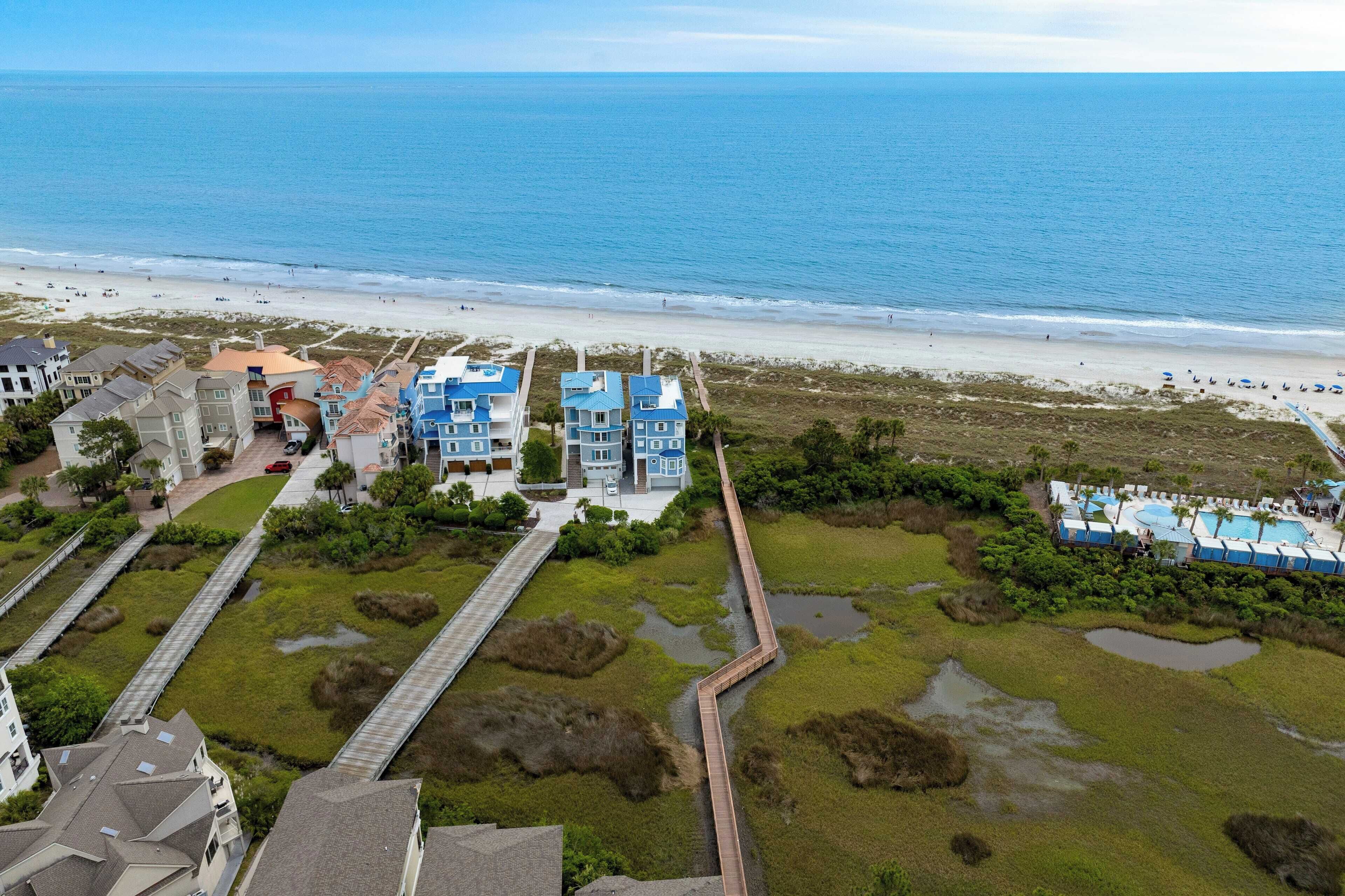 Een kusthotel met meerdere gebouwen, een strand en een promenade.
