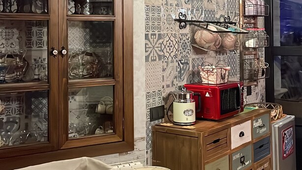 Una cucina con mobili in legno, un tostapane rosso e un frigorifero.