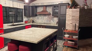 Una cucina moderna con mobili scuri, una grande isola e un rivestimento decorativo.