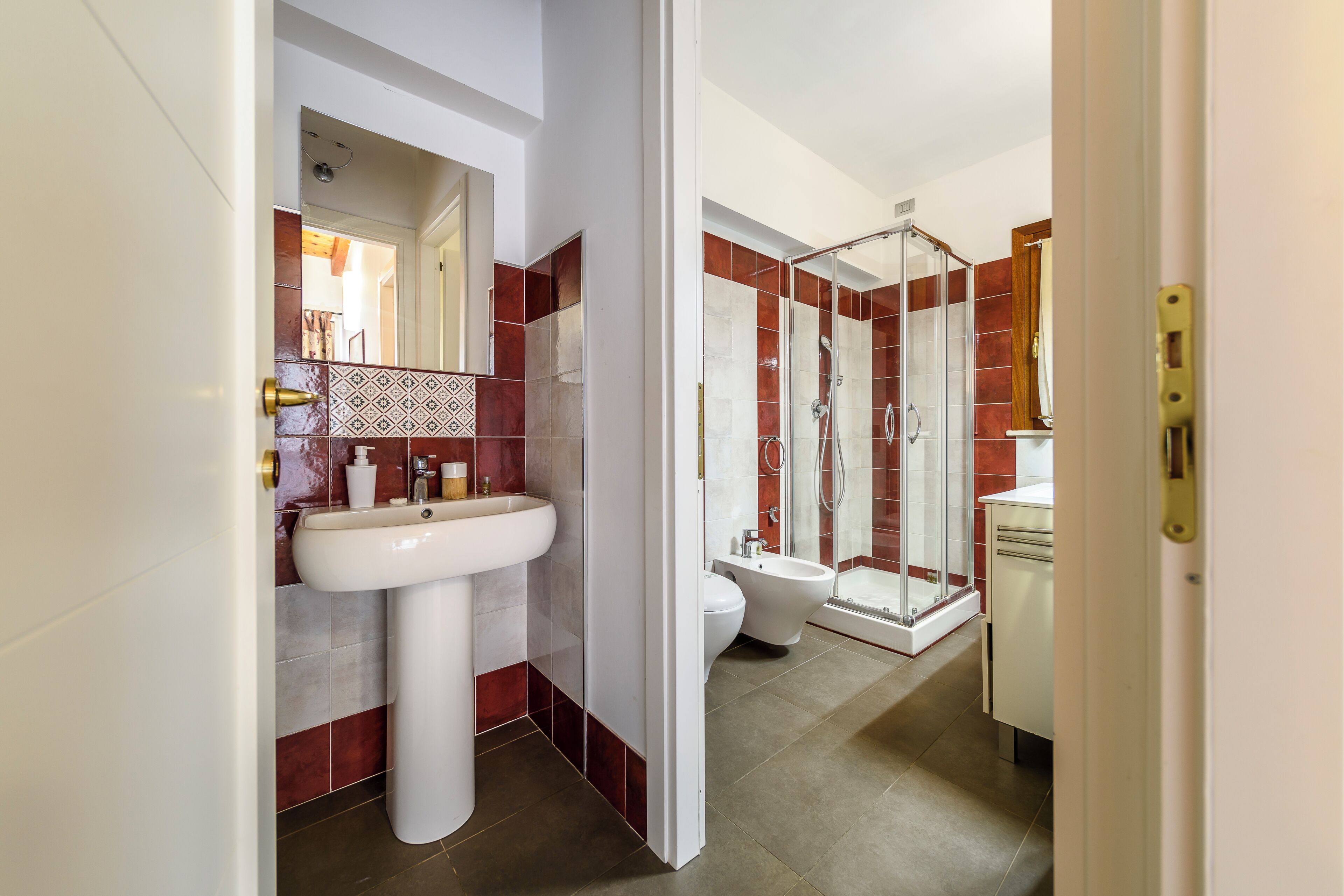 Ein modernes Badezimmer mit einem Standwaschbecken, einer Duschkabine und einer Toilette.