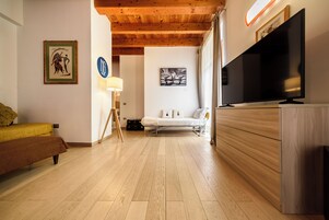 Una sala de estar moderna con un sofá, un televisor y obras de arte en las paredes.