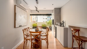 Una cocina moderna con comedor, sillas de madera y plantas en macetas.