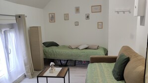A compact living space with a loft bed, a sofa, a coffee table, and a small side table.