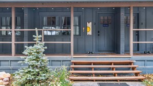 A building with a covered porch, a small Christmas tree, and a bench. - Mount Meeker (Allenspark)
