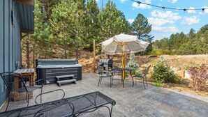 An outdoor patio with a grill, seating, and a hot tub. - Chief's Head Peak (Allenspark)