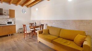 Una cocina con armarios de madera, un microondas y un comedor con mesa y sillas.