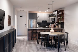 A modern kitchen with a central island, dark cabinetry, and pendant lighting. - Villa 23 Cabot Peaks Revelstoke Vacation (Revelstoke)