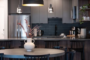 A modern kitchen with a central island, dark cabinetry, and pendant lighting. - Villa 23 Cabot Peaks Revelstoke Vacation (Revelstoke)