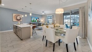 Un salon moderne comprenant un coin repas, une cuisine et une grande fenêtre agrémentée de rideaux.