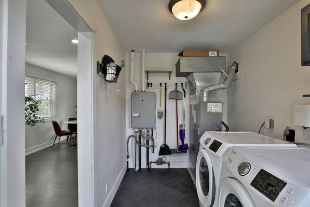 A laundry room with a washing machine, dryer, and stacked laundry baskets.