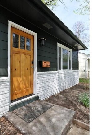 Traditional exterior with a wooden door and glass panels.