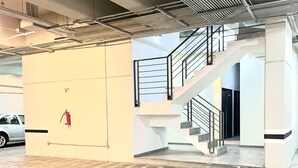 A modern parking garage with a staircase leading to an upper level.