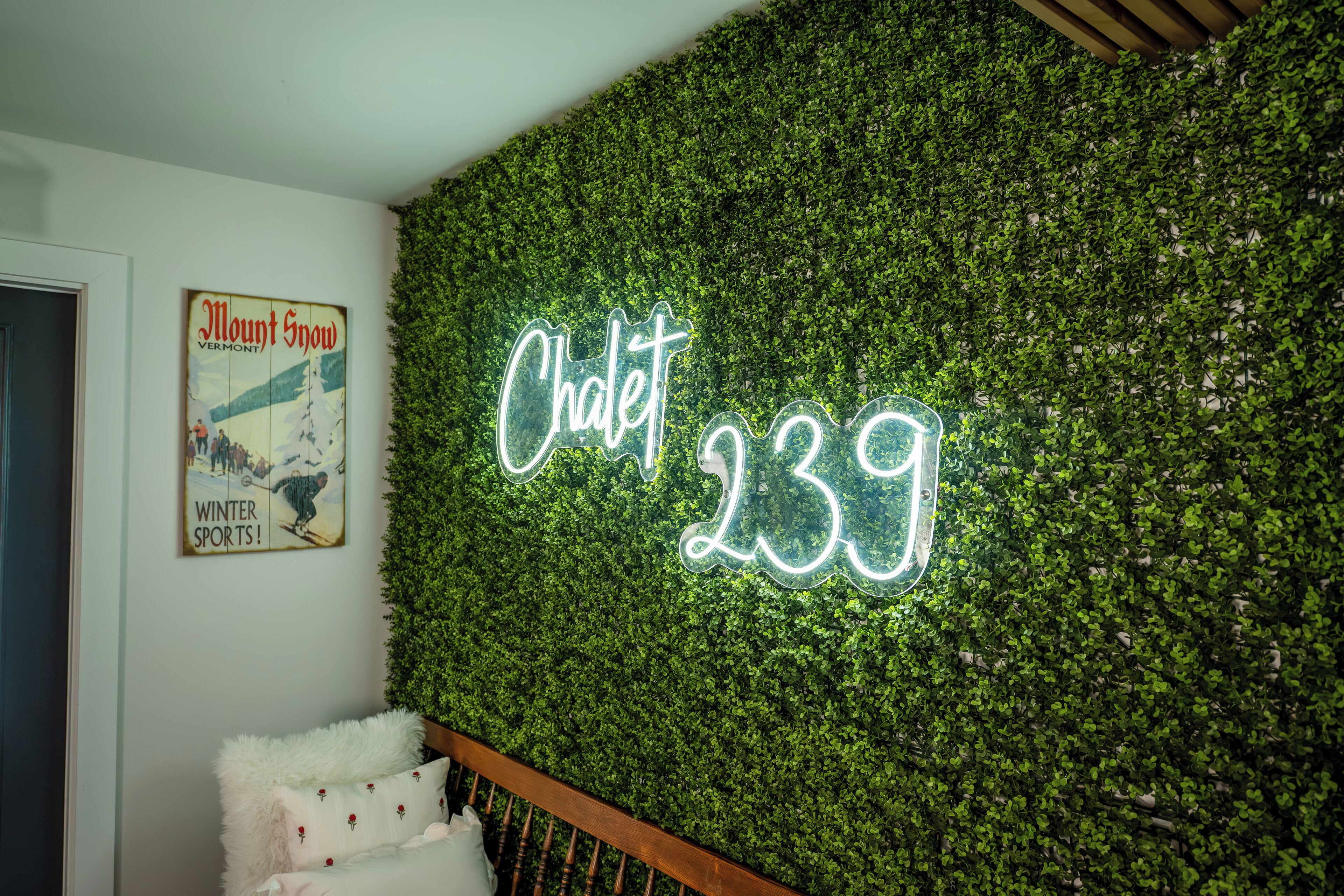 A wall with a neon sign reading "Chalet 239" and a vintage poster of "Mount Snow" with "Winter Sports!" text.