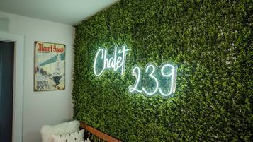 A wall with a neon sign reading "Chalet 239" and a vintage poster of "Mount Snow" with "Winter Sports!" text.