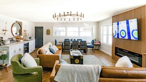 A modern living room with a dining area, a fireplace, and a television mounted on the wall. - Chalet 239 (West Dover)
