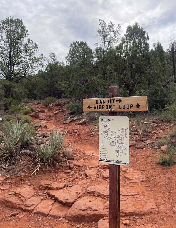 A trail sign with directions to Bandit Airport Loop and a map of Carroll Canyon Area Trails.