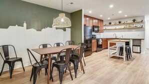 Una cucina moderna con mobili in legno, un tavolo da pranzo con sedie e una lampada a sospensione.