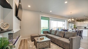 A modern living room with a sectional sofa, a coffee table, and a fireplace. - Hunt & Hike: Potholes State Park Home Hot Tub (Othello)