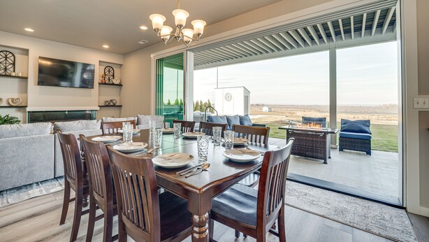 A dining area with a table set for six, a television mounted on the wall, and a view of the outdoors through large sliding doors. - Hunt & Hike: Potholes State Park Home Hot Tub (Othello)