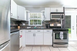 Fridge, microwave, oven, stovetop - 1703 NW 38th · Modern Peaceful Home w/ Patio & Game Room (Gainesville)