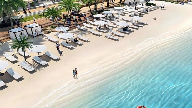 A beach with sun loungers and umbrellas, palm trees, and a sandy shore. - Creek Beach Roomy 3BR with terrace (Dubai)