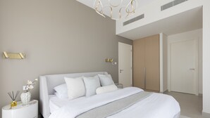 A modern bedroom with a large bed, bedside tables, and a wardrobe. - Creek Beach Roomy 3BR with terrace (Dubai)