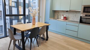 Una cocina moderna con armarios azul claro, una mesa de comedor de madera y sillas.
