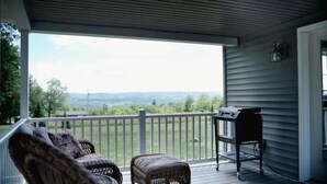 A covered porch with wicker furniture, a grill, and a view of the landscape. - Luxury on Seneca Wine Trail, 3 King Beds with Awesome Country View (Watkins Glen)