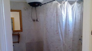 A bathroom with a shower curtain featuring a bird pattern, a sink, and a mirror on the wall.