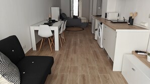 Un espacio habitable compacto con comedor, kitchenette y sofá.