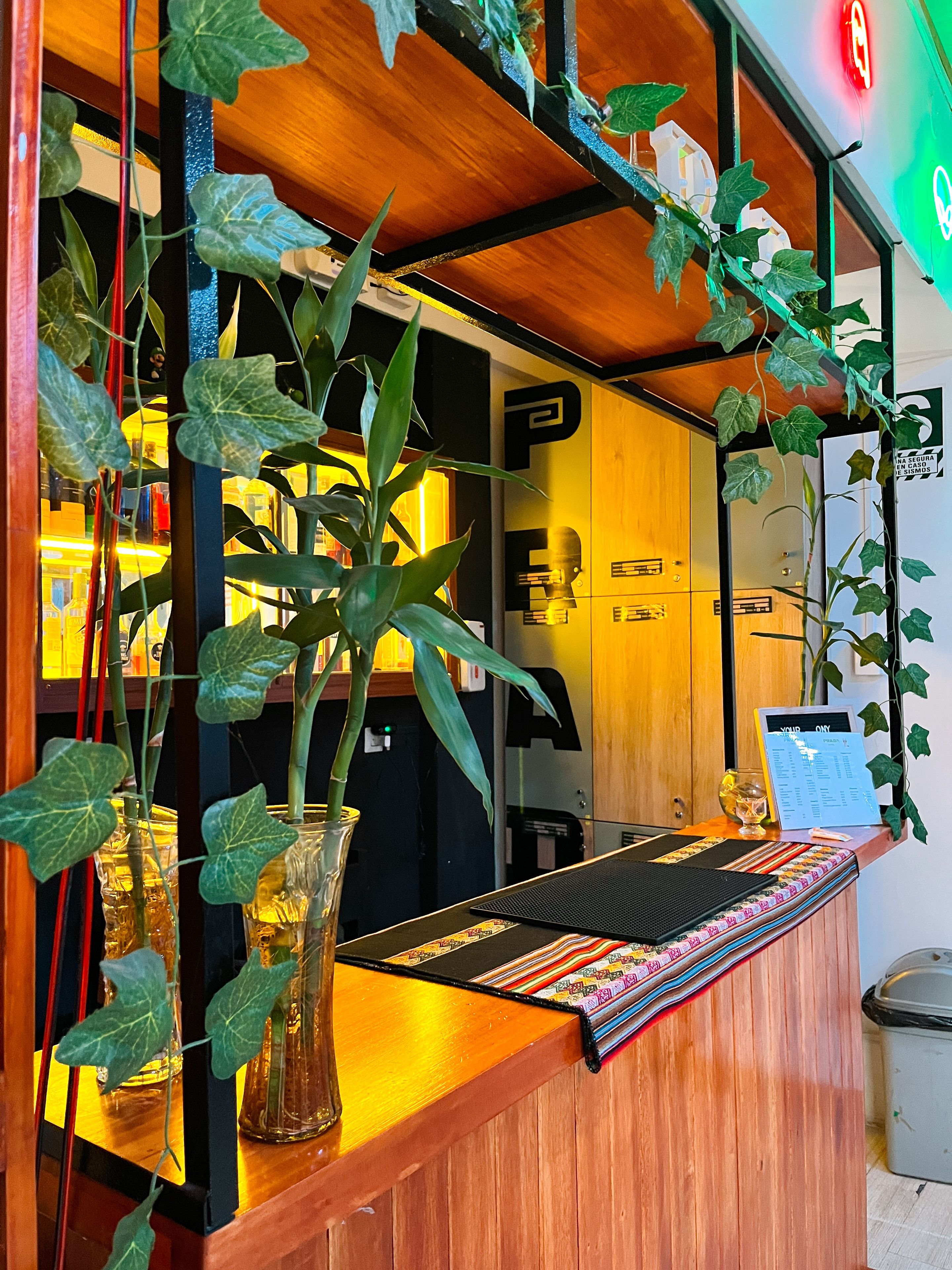 A reception desk with a wooden finish, a black mat, and a menu stand.