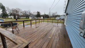 Guests can enjoy an outdoor space with a deck and bench overlooking the surrounding neighborhood.