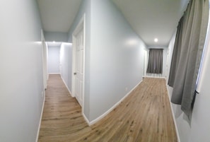 Leading to a door and a window, this hallway offers a glimpse into the property's interior.