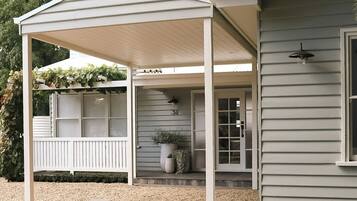 A covered porch with a white railing, a potted plant, and a house number 34.